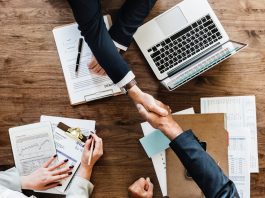 two people shaking hands across a table. foreign direct investment debate ideas